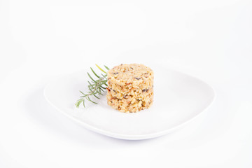 Risotto with button mushroom and bacon decorated with rosemary twig on a plate on a white background