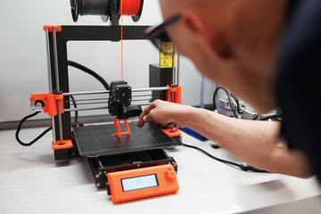 Man checking 3d printer with display, process of making things on 3d printer in laboratory - 340712905