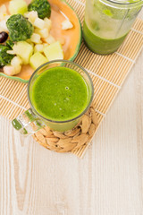 spinach green smoothie on wooden table 