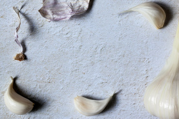 Fresh cloves of garlic, dry garlic skin on the stone background. Flat lay frame pattern, copy space. Close- up, top view
