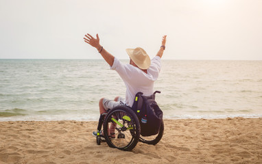 Obraz na płótnie Canvas Disabled man in a wheelchair on the beach.