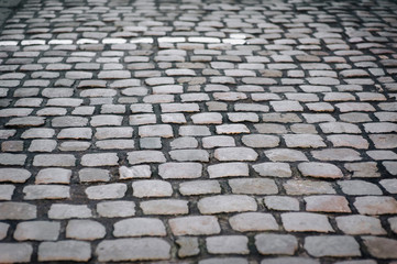 The gray paving stones close up. The texture of the old dark stone. Vintage, grunge. Road surface.
