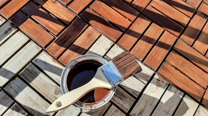 Repair concept. the brush lies on a jar with a protective varnish for wood. Half of the terrace is...