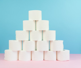 Image of toilet paper tower at pastel background.