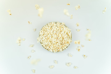 Dreamy image from above of popcorn falling at bowl full of popcorn.