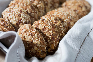 Oatmeal cookies, sprinkled with sesame seeds and almonds are in a beige napkin in a baking dish after cooking