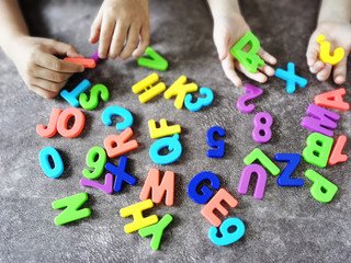 Kids learn alphabets at home. Preschool education. Multi-colored letters and numbers. Home schooling.