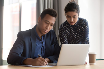 Secretary indian woman brought for signature documents for signing to company owner african ethnicity boss, multi-ethnic colleagues working together affirming checking papers, use online business app