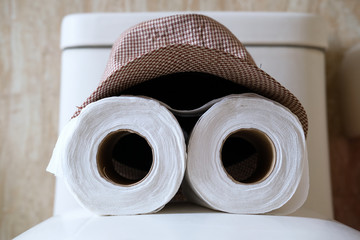 close up of roll of toilet paper and hat 