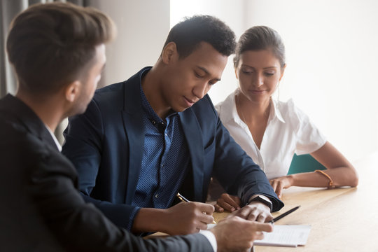 Advisor meet with clients in office, african ethnicity man european woman diverse family signing lease or fill for loan agreement after discuss terms and conditions, buy sell property services concept - Powered by Adobe