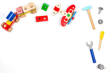 Kids toys background. Wooden train, construction plane and toy tools kit on white background. Top view, flat lay