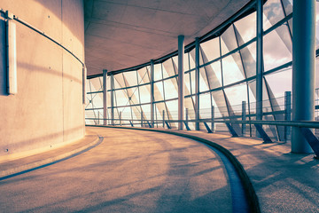 Obraz premium Interior of a modern building, concrete, steel and glass construction, low-angle driveway perspective, tall windows