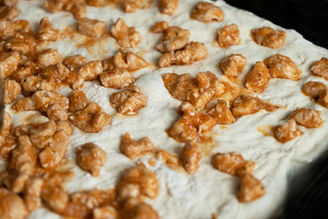 Pizza dough with fried meat, closeup
