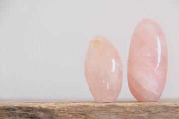 Polished crystals rose quartz gemstone on a wooden table. Copy, empty space for text
