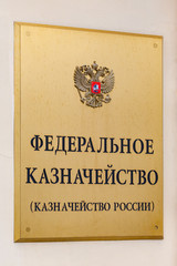 Close up view of the gilded plaque with coat of arms and inscription -The Federal Treasury (the Russian Treasury).