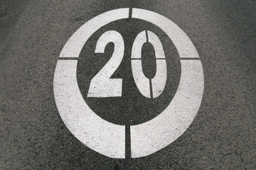 Fototapeta premium Traffic sign painted on the asphalt of the road marking the speed limit at 20