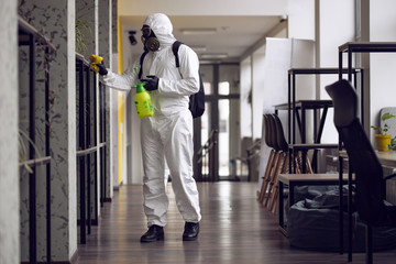 Cleaning and Disinfection at town complex amid the coronavirus epidemic. Professional teams for disinfection efforts. Infection prevention and control of epidemic. Protective suit and mask - obrazy, fototapety, plakaty