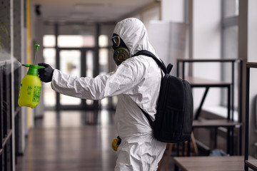 Cleaning and Disinfection at town complex amid the coronavirus epidemic. Professional teams for disinfection efforts. Infection prevention and control of epidemic. Protective suit and mask