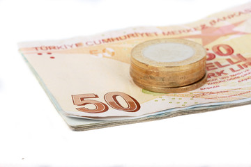 Turkish lira coins in a row on hundred banknotes.