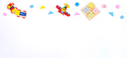 Baby kids toys banner background. Wooden educational geometric stacking blocks toy, constructor airplane, wooden train and blocks on white background. Top view