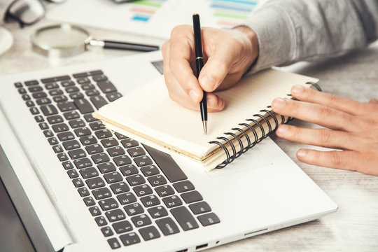 man hand notepad on comuter keyboard