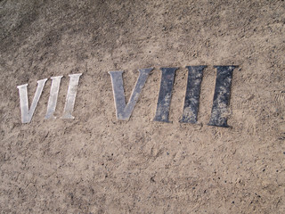 Roman numerals of a sundial embedded in ground, Warsaw, Poland