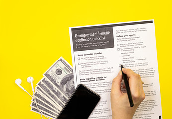 application for unemployment benefits with money. the concept of applying for insurance payments from the state in case of dismissal due to covid-19 coronavirus