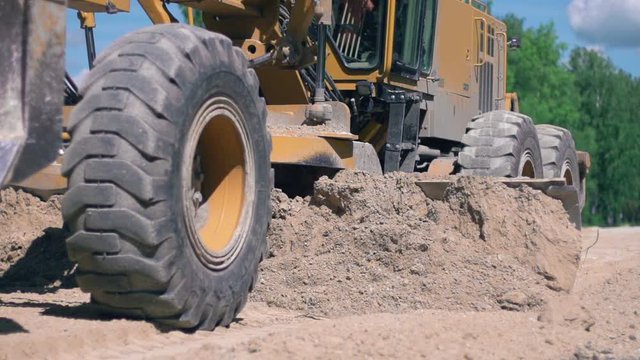 Road works. tractor leveling the ground in rural landscape. Slow motion