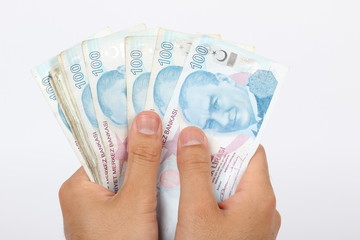 Turkish lira coins in a row on hundred banknotes.