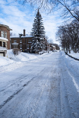 Fototapeta na wymiar Houses and street covered with lot of snow in Canada
