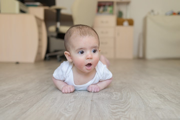 Fototapeta premium Newborn baby. A little boy in white clothes. Beautiful portrait of a toddler. Big-eyed baby.