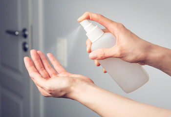 Female hands that applying alcohol spray or anti bacteria spray to prevent spread of germs, bacteria and virus