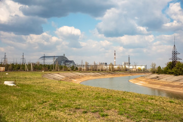 Fototapeta na wymiar fourth block of Chernobyl nuclear power plant with new Arch shelter built in 2016 and cooling pond