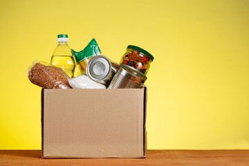 Food Donation concept. Donation Box With food For Donation On Yellow Backround. Assistance To The...