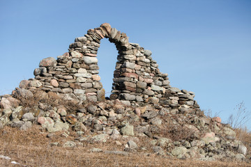 Stone wall ruins with doorway left over from long ago. - obrazy, fototapety, plakaty