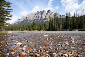 View of a large mountain from the edge of a rocky river bed.