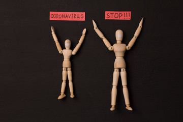 Two figures of a wooden man are asked to stop coronavirus. Pandemic, panic, recovery, red words on...