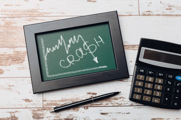 charts of economics and stock markets on a chalk board. financial crisis concept.