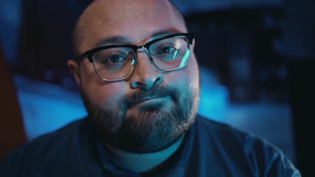 Portrait of bearded fat man in glasses making knock gesture to camera