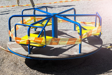 Merry-go-round carousel playground for kids with biohazard forbidden STOP tape ribbon during...