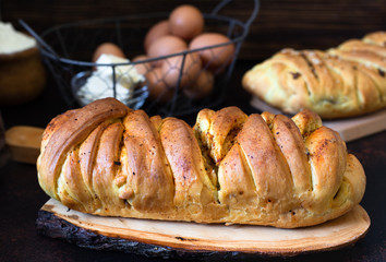 A traditional salty pie of Russian cuisine called kulebyaka. Ingredients for the dough butter, flour, eggs. Two closed pies with different fillings, the first with meat and mushrooms, the second with 