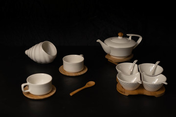 Modern white tea set on a black background.