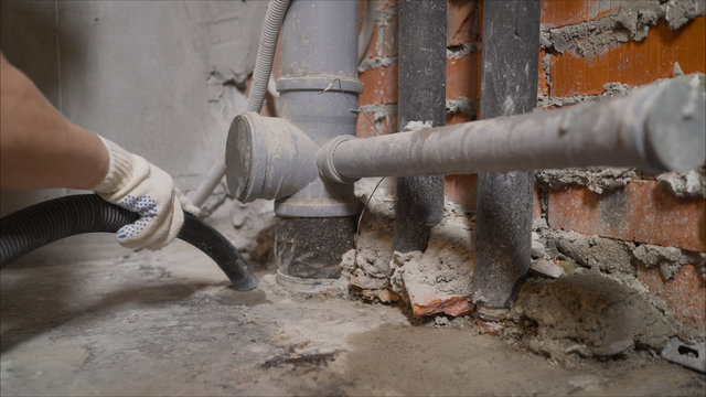 Room cleaning with an industrial vacuum cleaner. Man Vacuuming a Construction Site