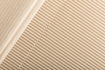 Carton or cardboard packing material. Texture of corrugated paper sheets made from cellulose. Supplies for creating boxes and packaging. Pasteboard background. Natural brown cardboard surface.