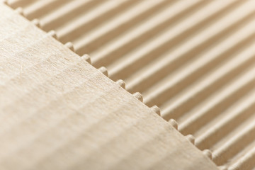 Carton or cardboard packing material. Texture of corrugated paper sheets made from cellulose. Supplies for creating boxes and packaging. Pasteboard background. Natural brown cardboard surface.