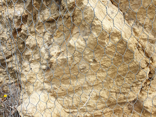 The rock is surrounded by a wire mesh. Protection from falling stones.