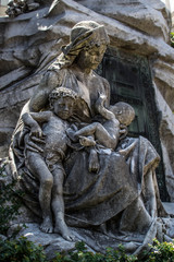 Fototapeta na wymiar Estatua de mujer con sus dos hijos en brazos