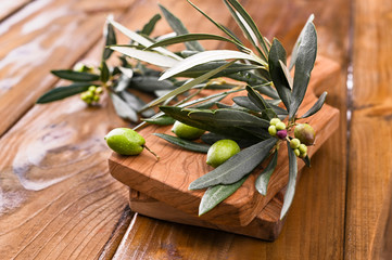 Olive branches and berries olives close-up on a wooden background. Copy space