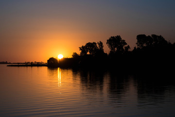 sol escondiéndose al atardecer en un lago 