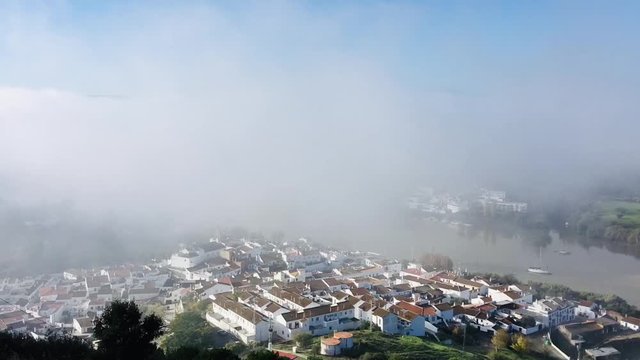 Time-lapse de la bruma del r&iacute;o Guadiana levant&aacute;ndose a lo largo de la ma&ntilde;ana dejando al descubierto los pueblos de Sanl&uacute;car de Guadiana en Espa&ntilde;a y Alcoutim en Portugal.